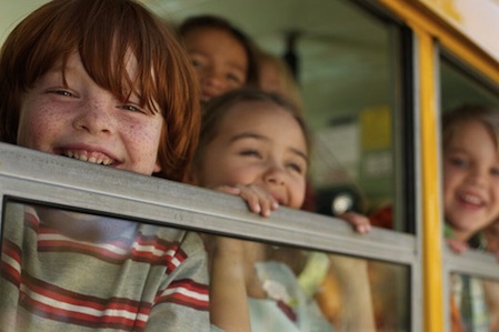 excited kids on a school bus